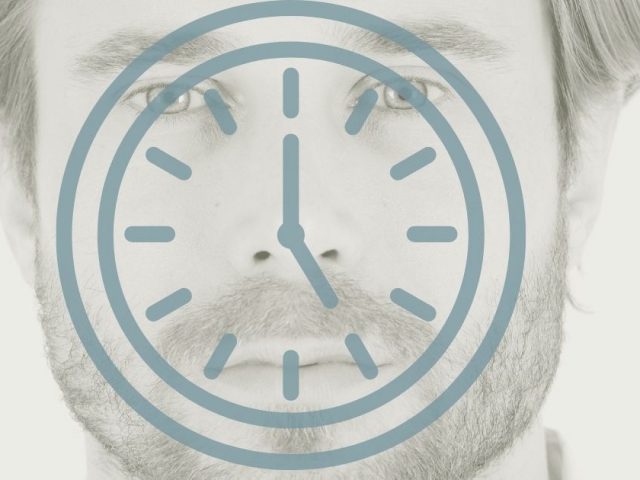 Eine Uhr vor dem Gesicht